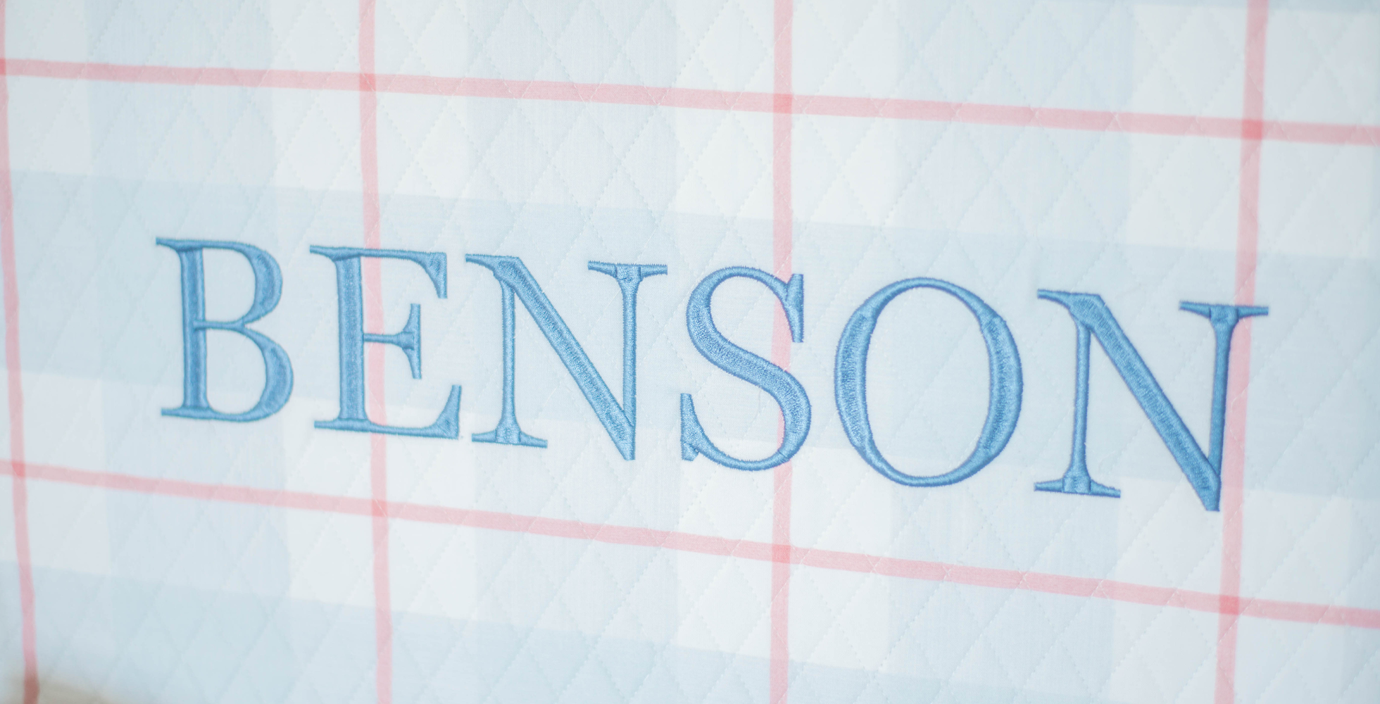 Text 'BENSON' embroidered on a fabric with a grid pattern