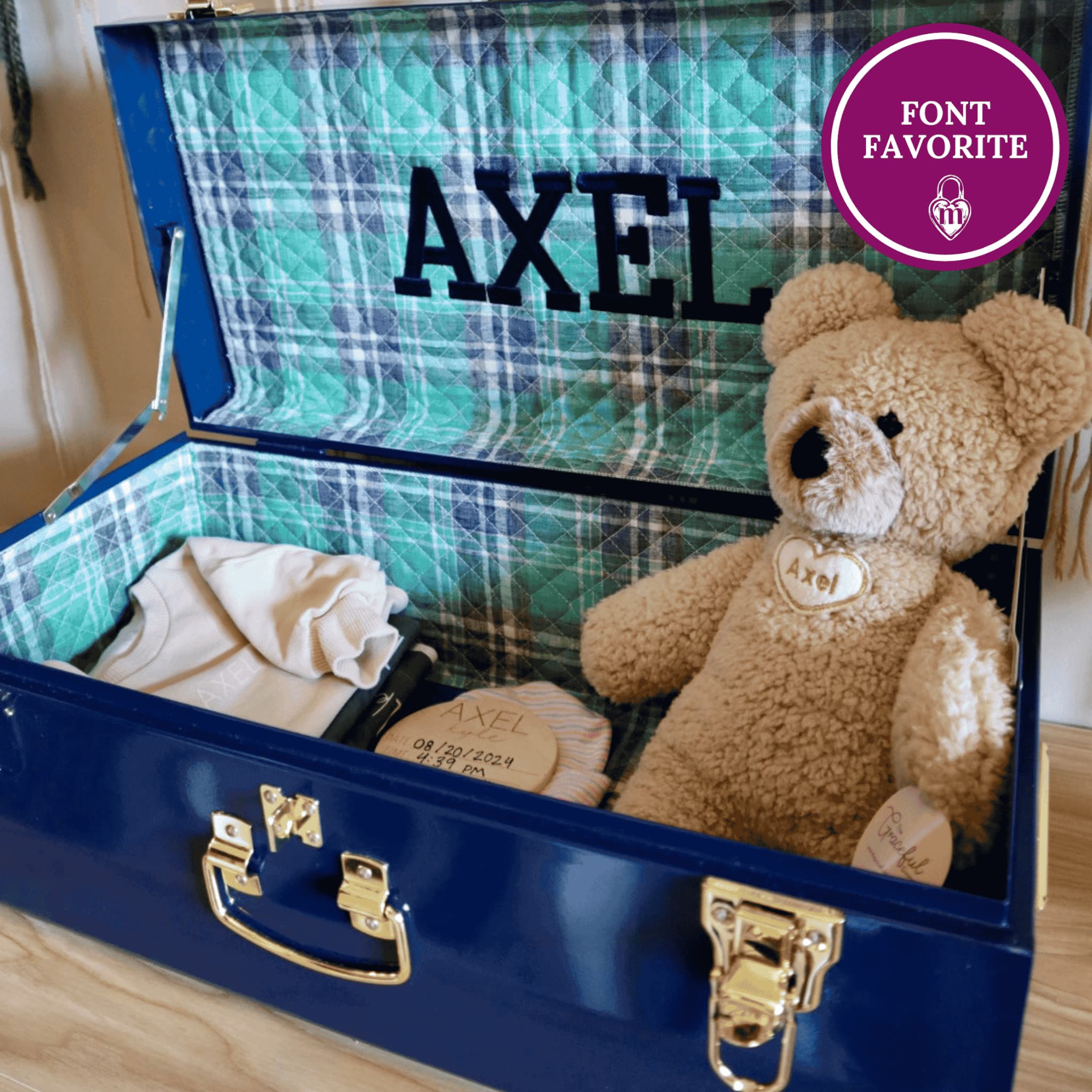 Blue memory box with plaid interior, teddy bear, and baby clothes, featuring the name 'Axel' in embroidery
