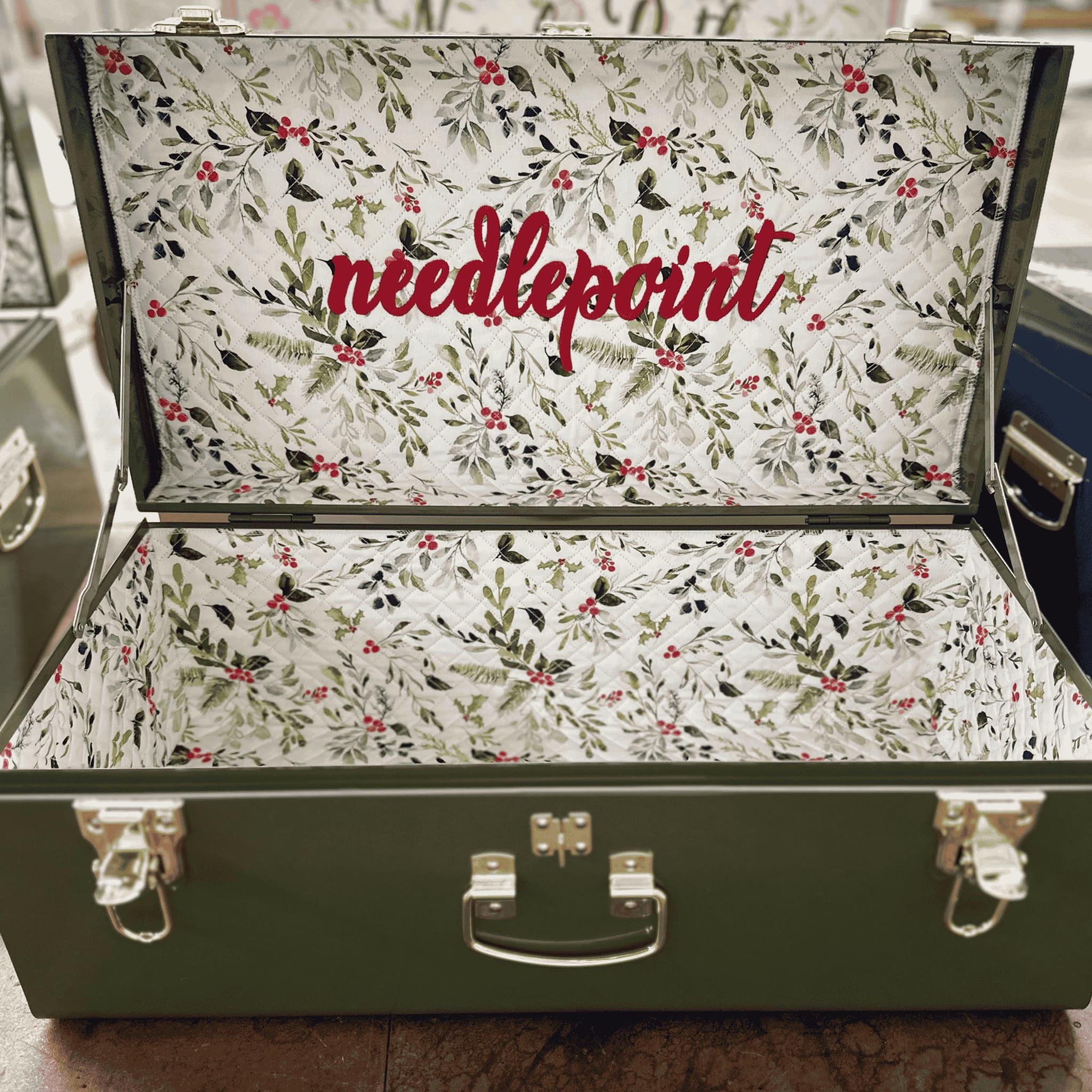 holiday needlepoint box with 'needlepoint' text on a wooden surface.